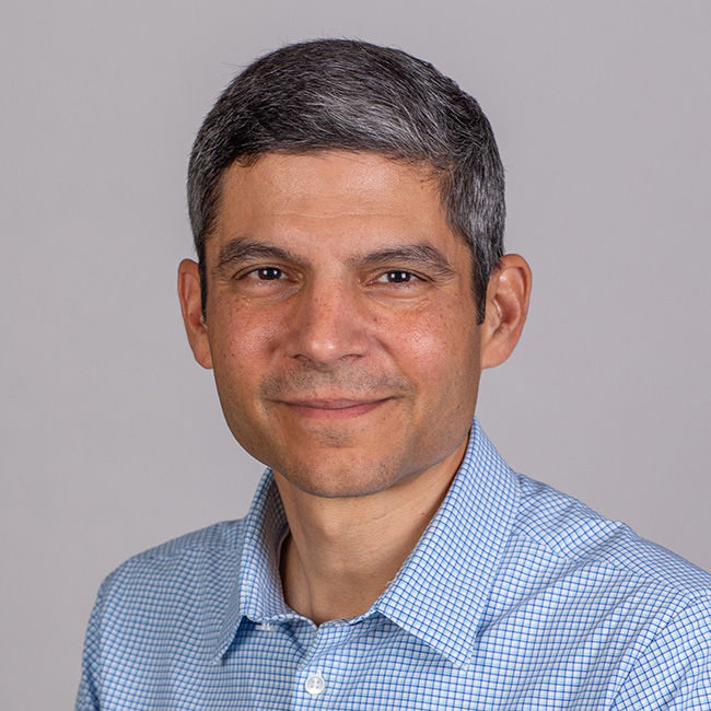 man in blue and white shirt smiling at the camera