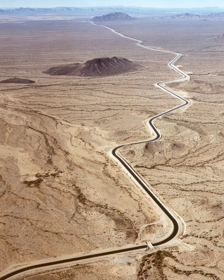 desert landscape showing a canal for water zigzagging through it