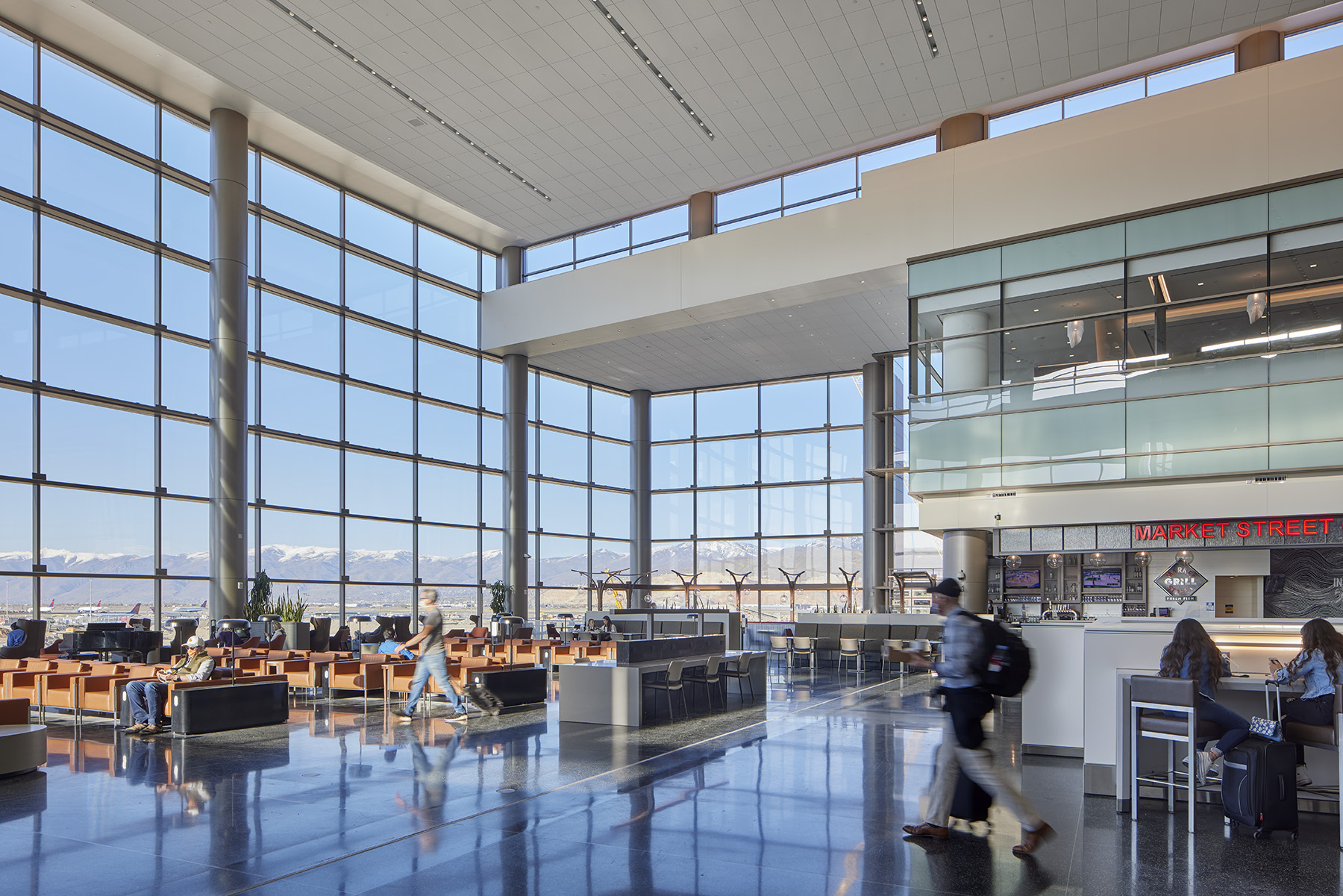 airport terminal with two-story windows and seats and restaurants