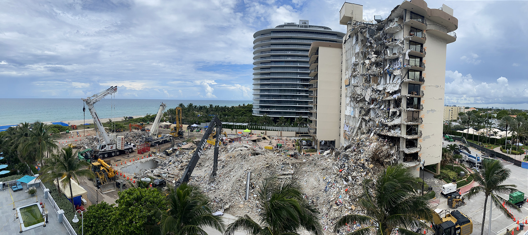 partially collapsed multifloor building. There is lots of building debris in the foreground.