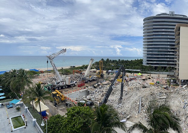 partially collapsed multifloor building. There is lots of building debris in the foreground.