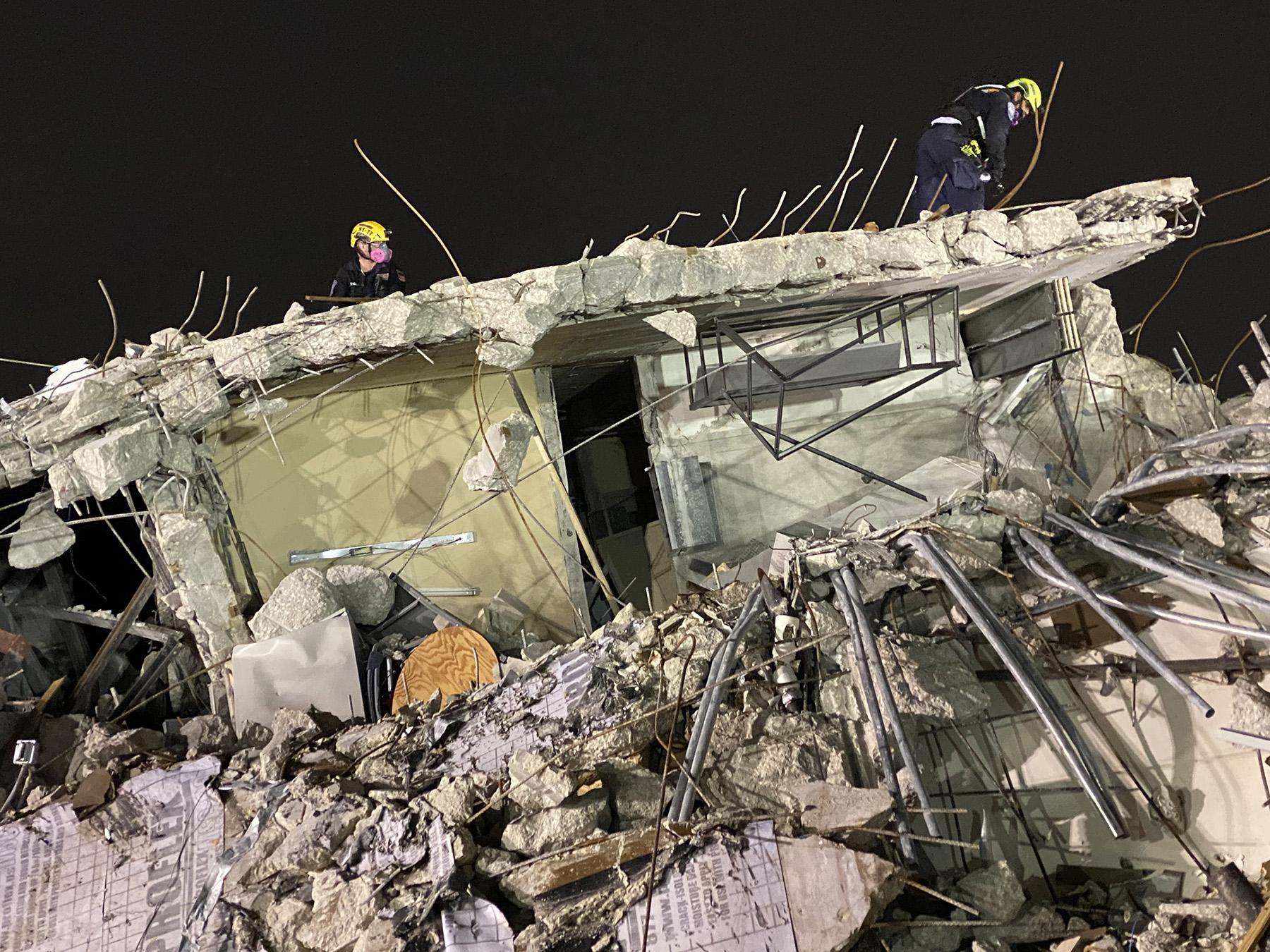 rescue workers work at a disaster site at night