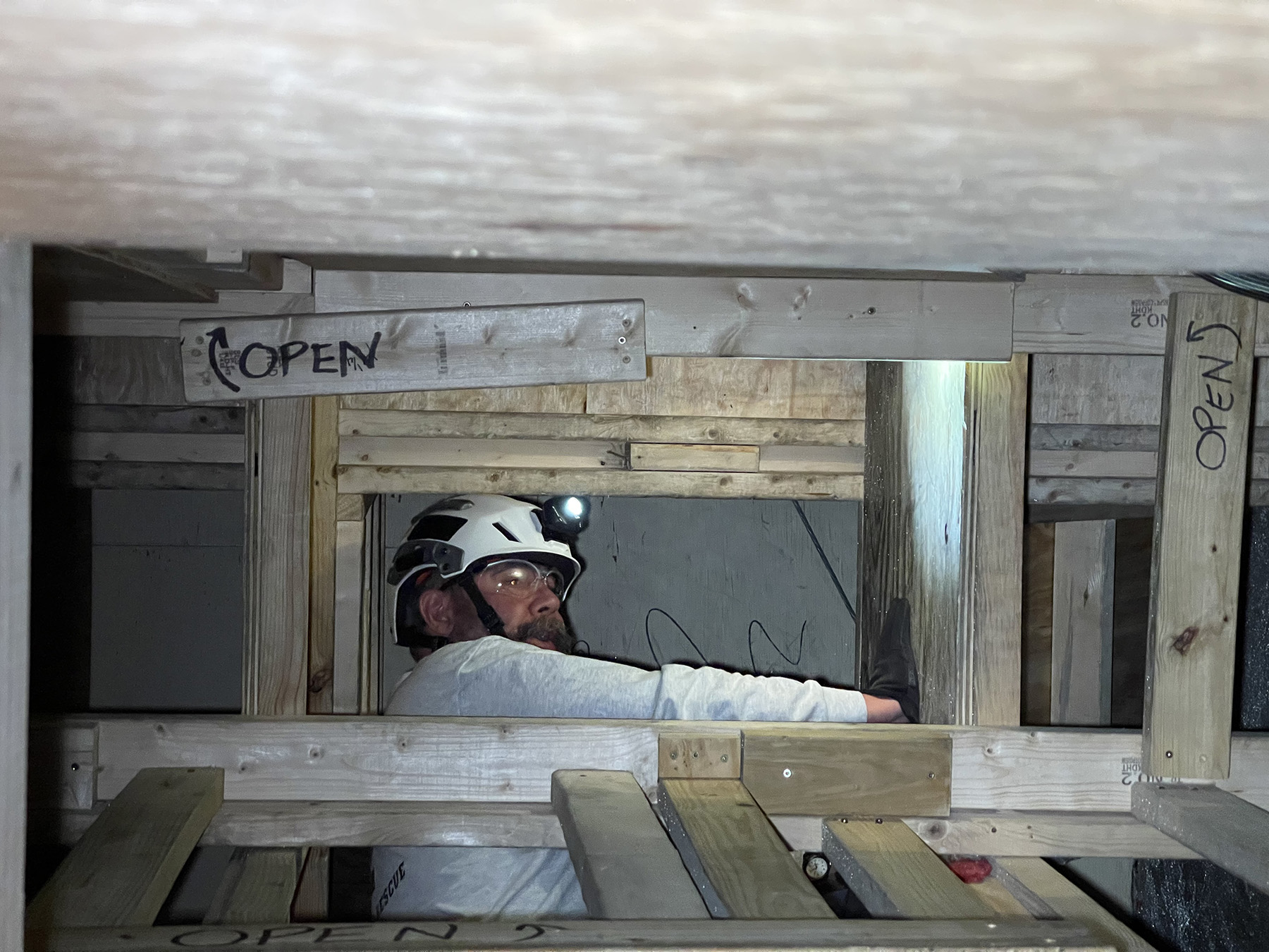 man in tight space wearing helmet with flashlight on it