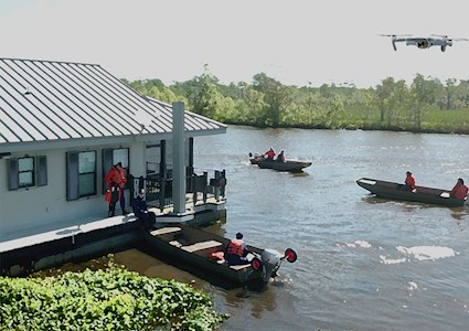 image shows people in boats wearing life jackets surrounded by greenery
