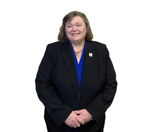 woman with short brown hair in a blue shirt and black suit.