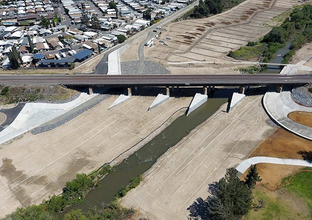 Photograph shows scour protection features installed at the base of the bridge.