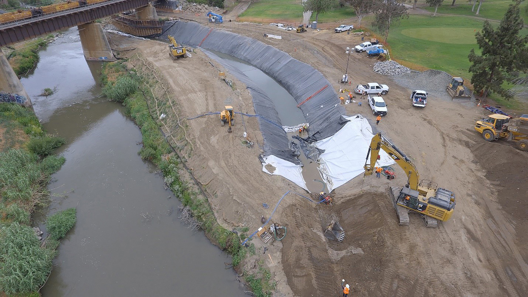 Construction photo showing diversion of the Santa Ana River. The natural river alignment is on the left and the construction area is on the right. 