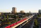red train moves along train tracks amidst a city scape