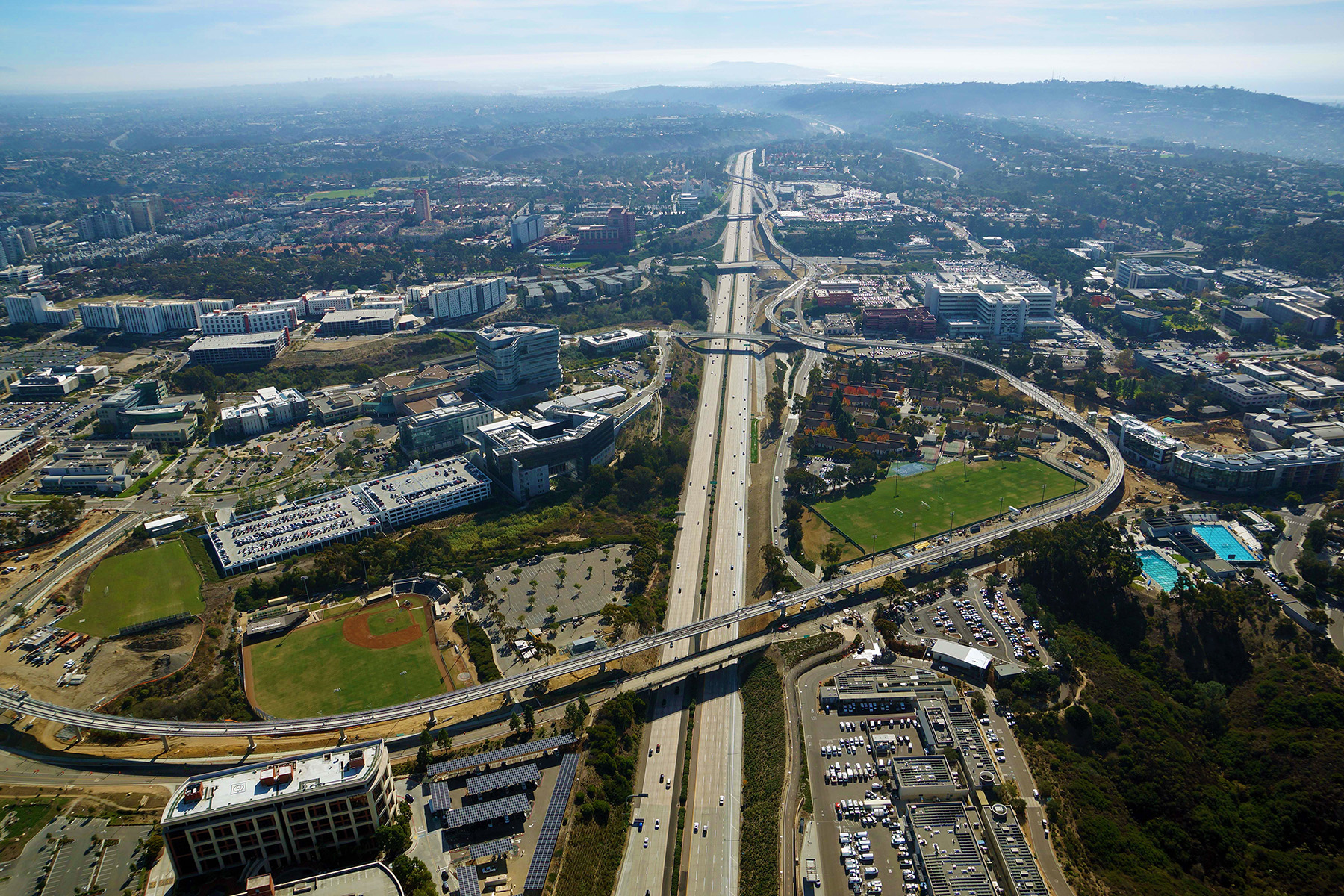 Aerial shot of a portion of san diego showing parts of the trolley extension and buildings scattered throughout the landscape