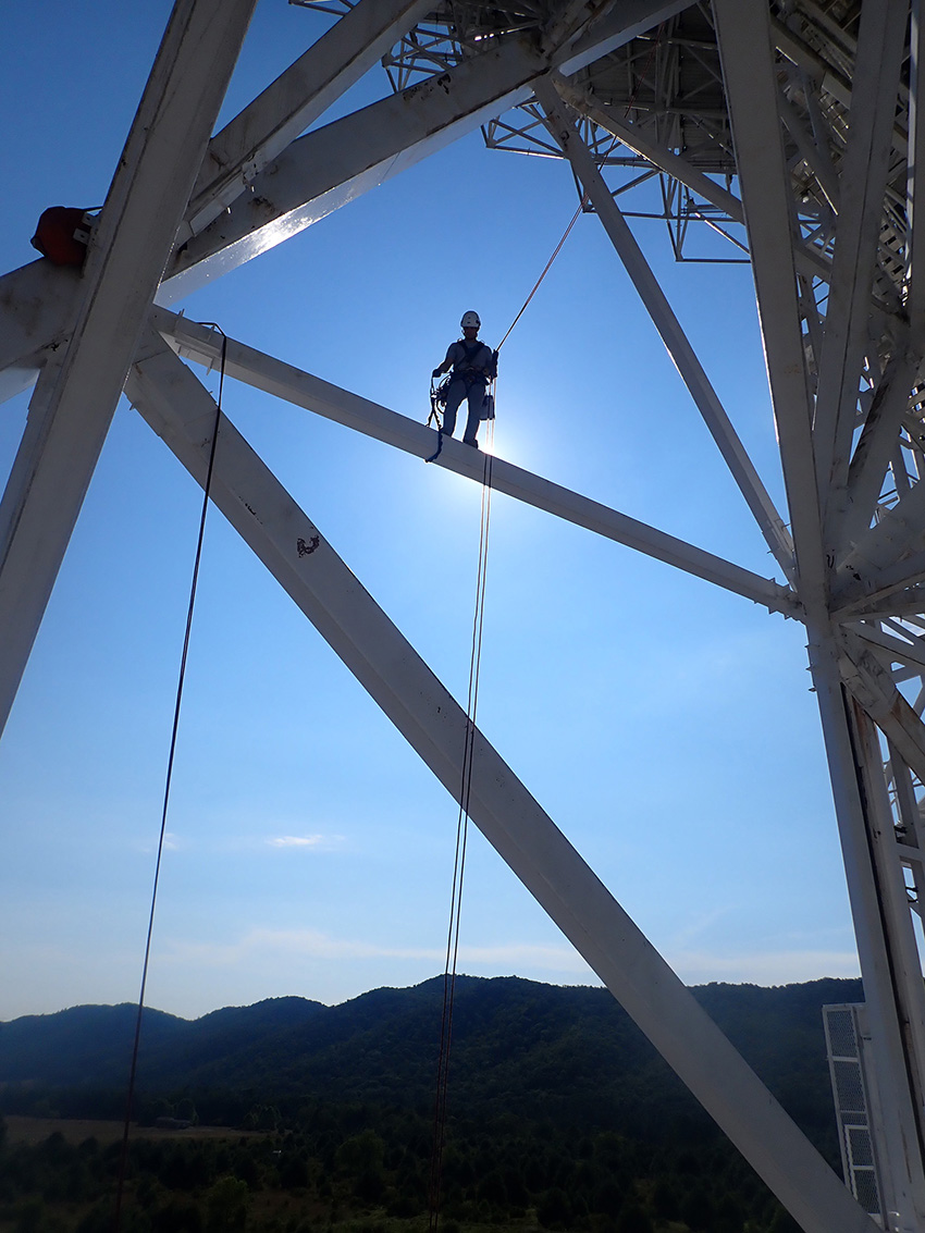 Man standing on a telescope.