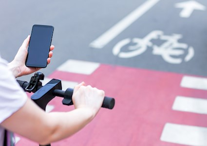 person on bicycle holding a phone