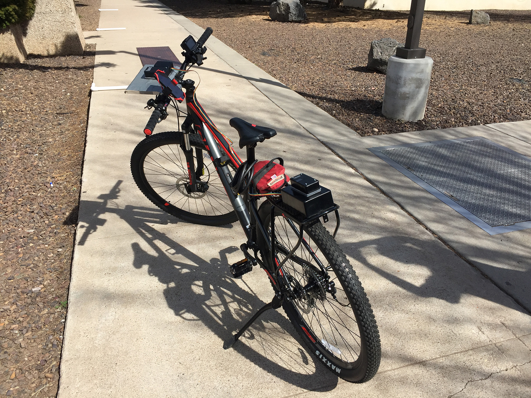 picture of a red bike parked on pavement.