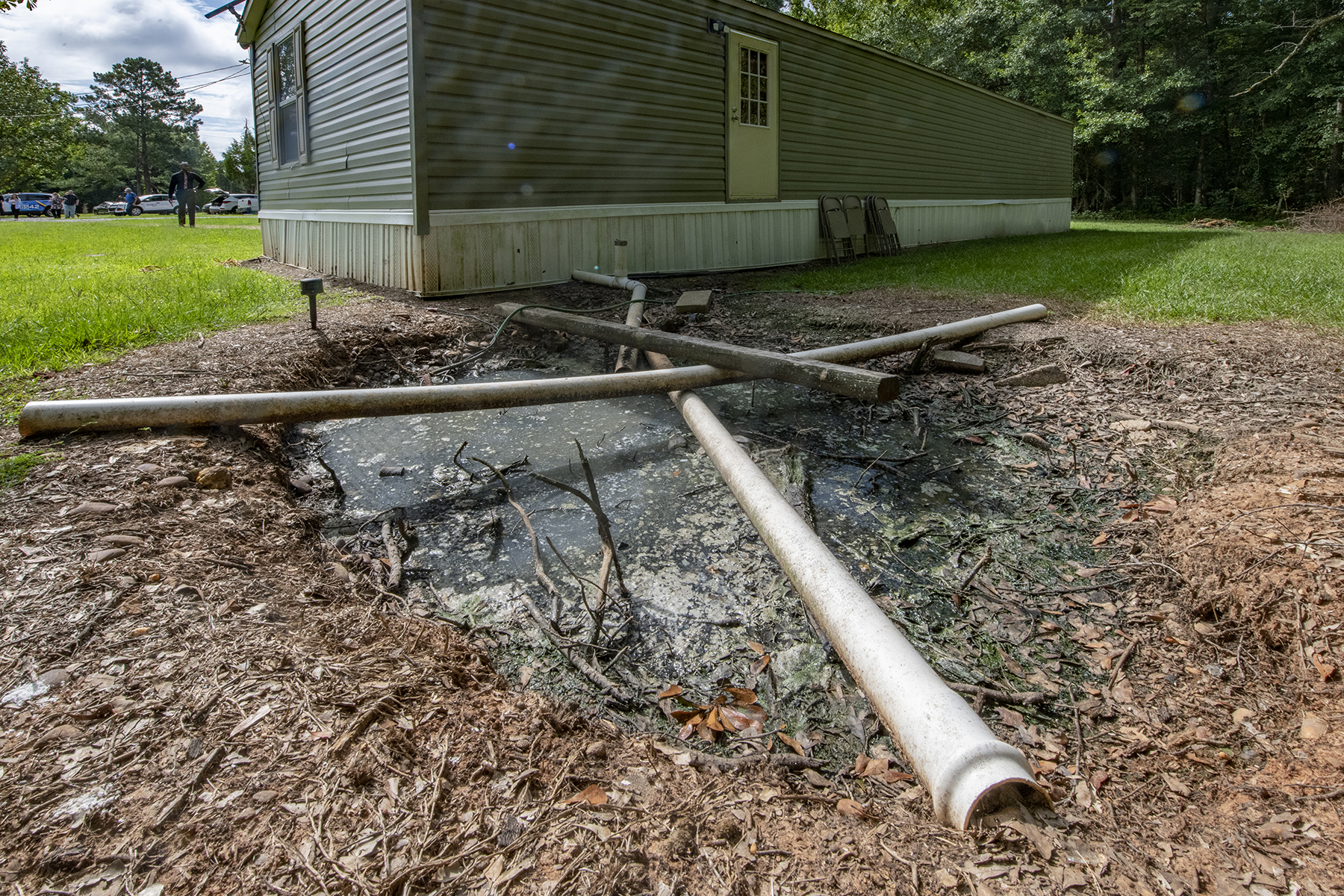 straight pipe discharging untreated wastewater into a back yard