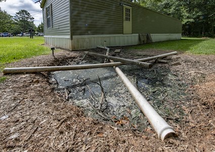 STRAIGHT PIPE RELEASING UNTREATED SEWAGE INTO A BACKYARD