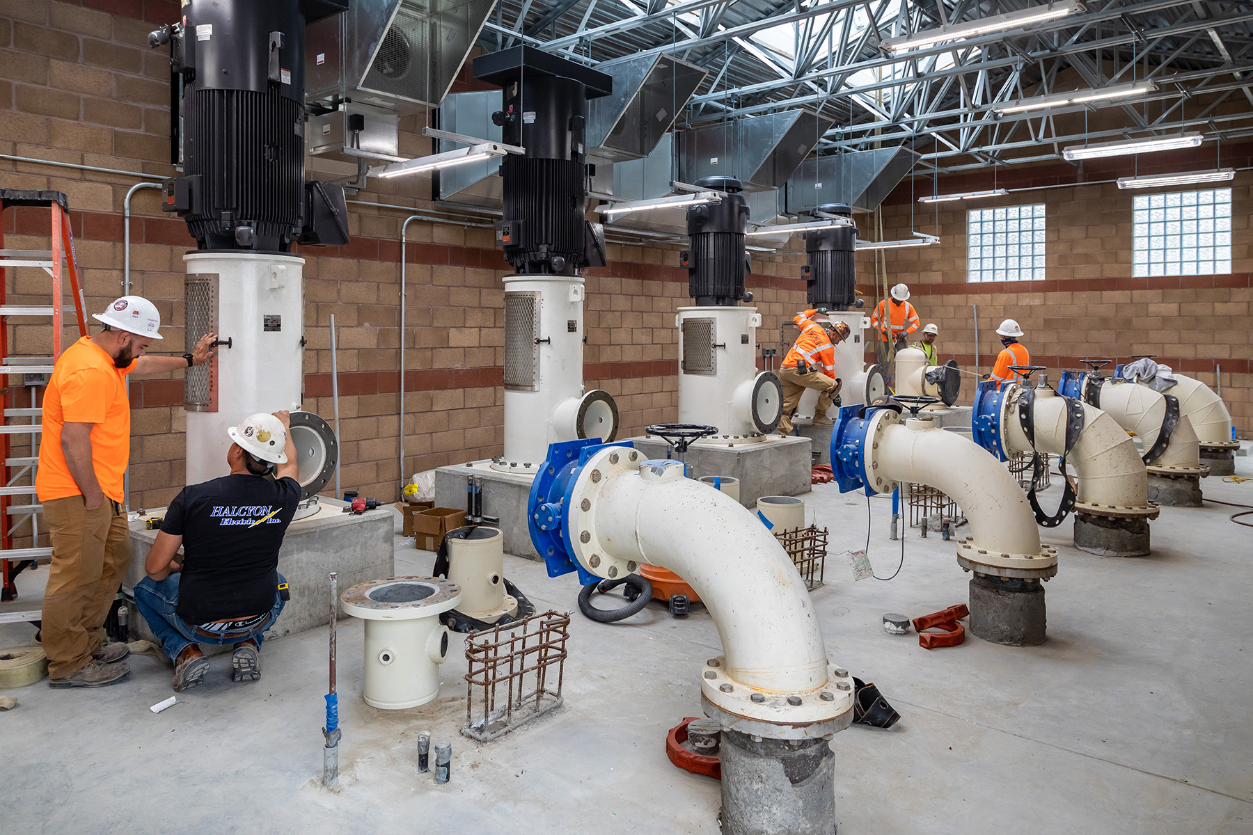 Men inside a room monitoring water pumps