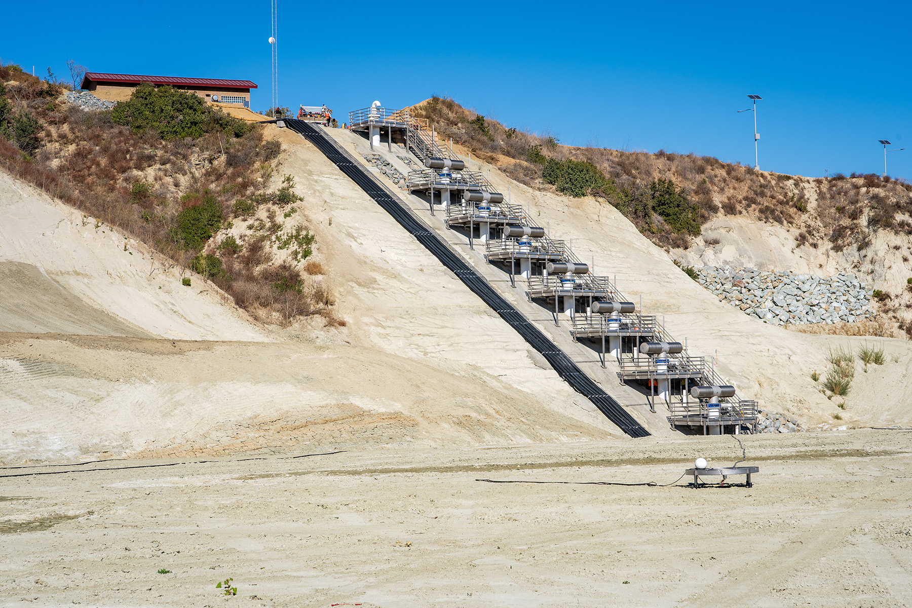 An inclined inlet outlet structure sitting in a sandy pit