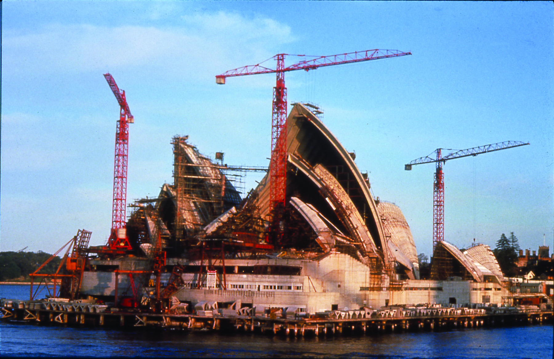 construction photo showing cranes as they erect the roof of the building