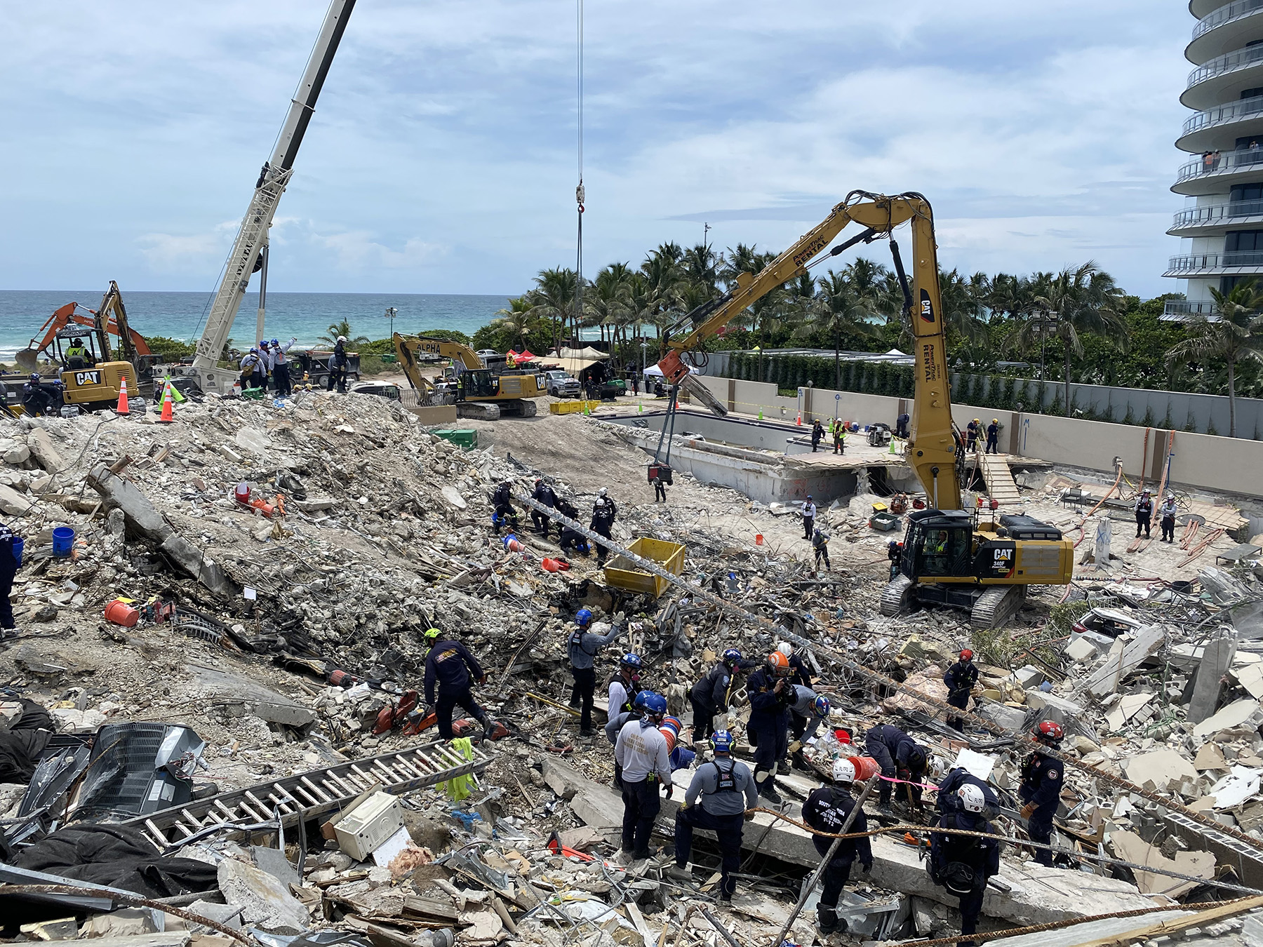 People are inspecting the rubble from a collapsed building.