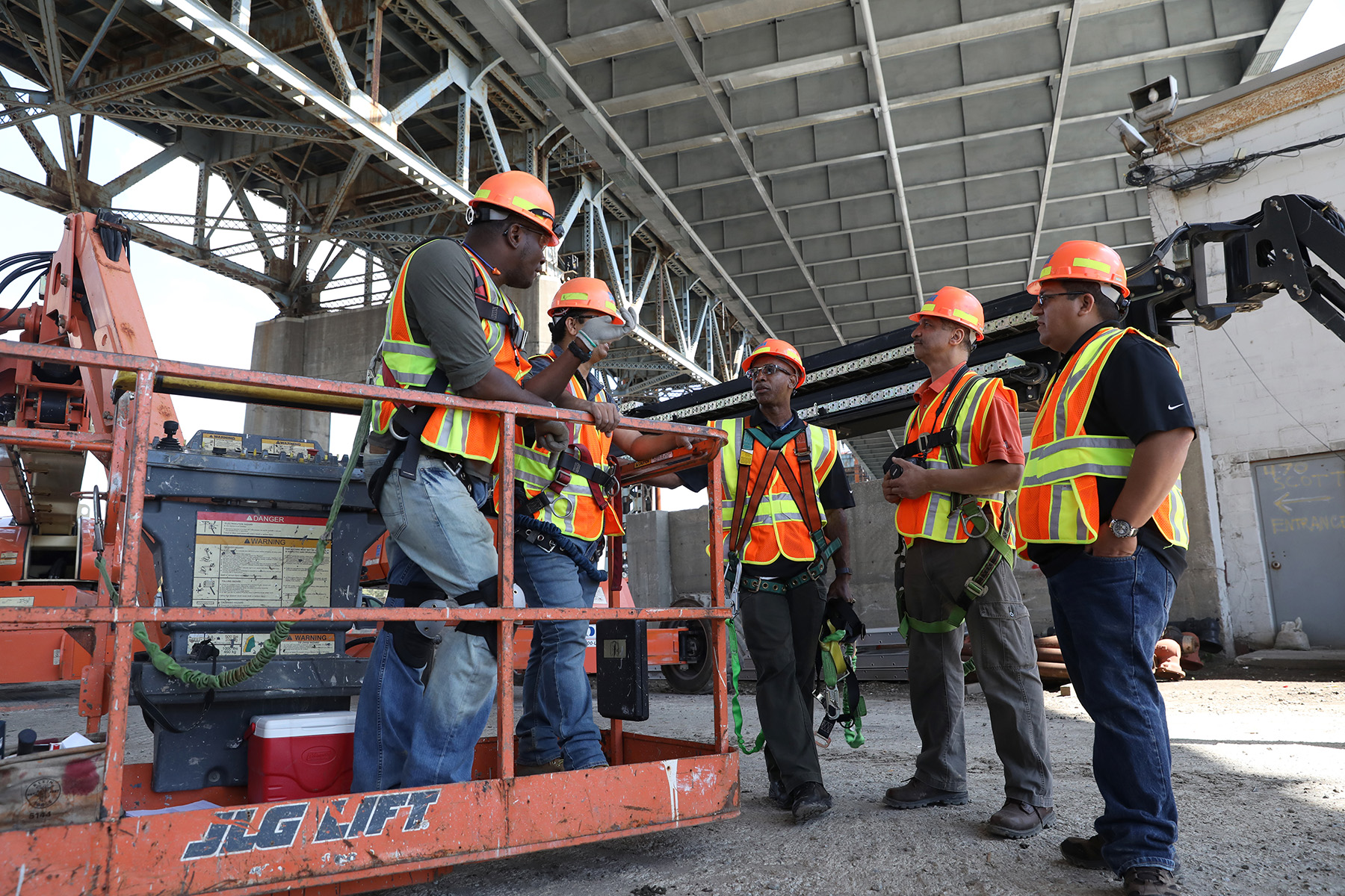 A group of men in safety gear are having a discussion.