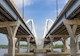 Photo shows the undersides of the twin spans of a bridge, including the piers, foundations, and decks 