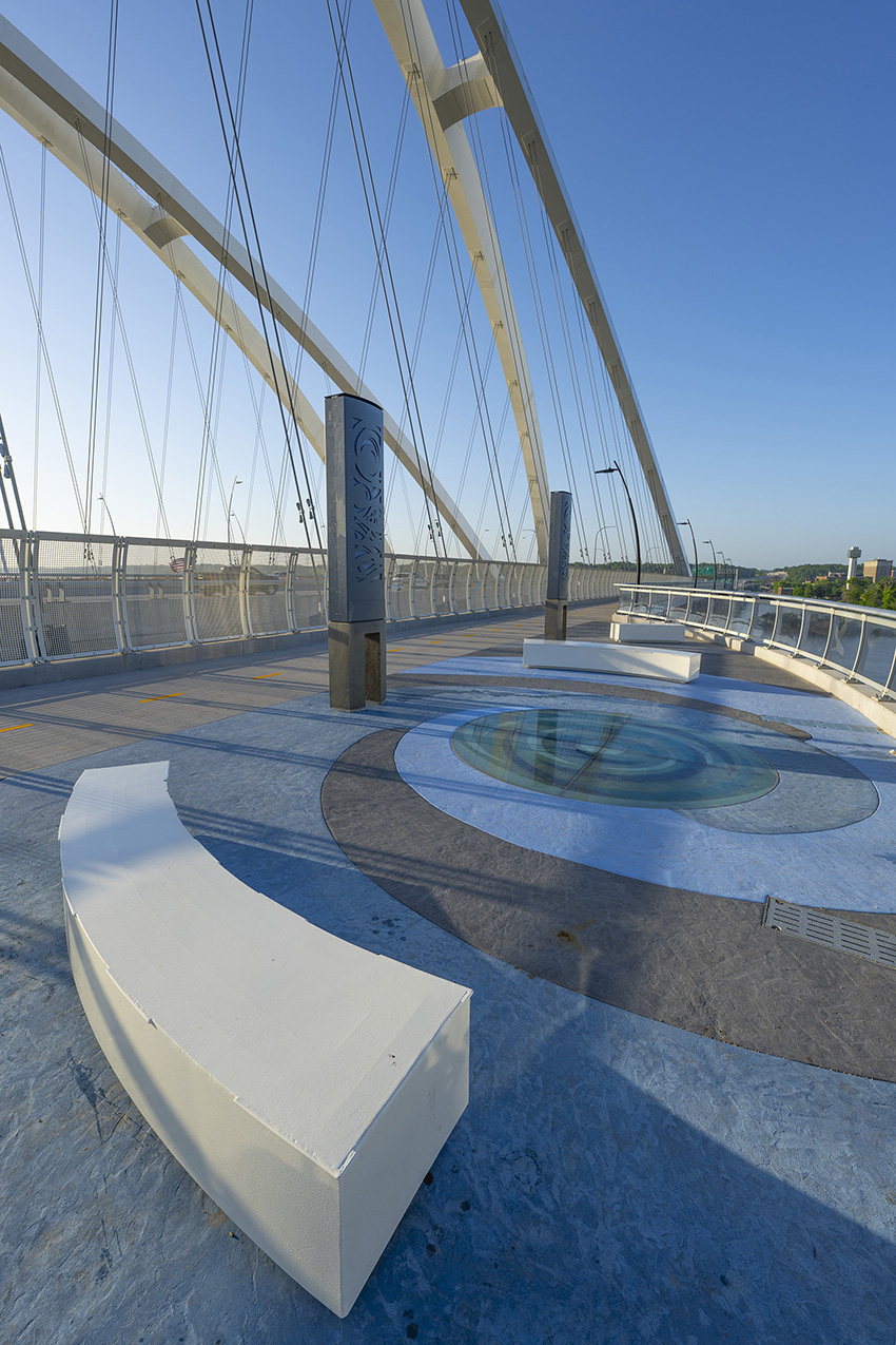 At the midpoint of a bridge span is an overlook, walkway, and sitting area for pedestrians and bicyclists. There is also a glass oculus in the floor of the span between two semi-circular benches. 