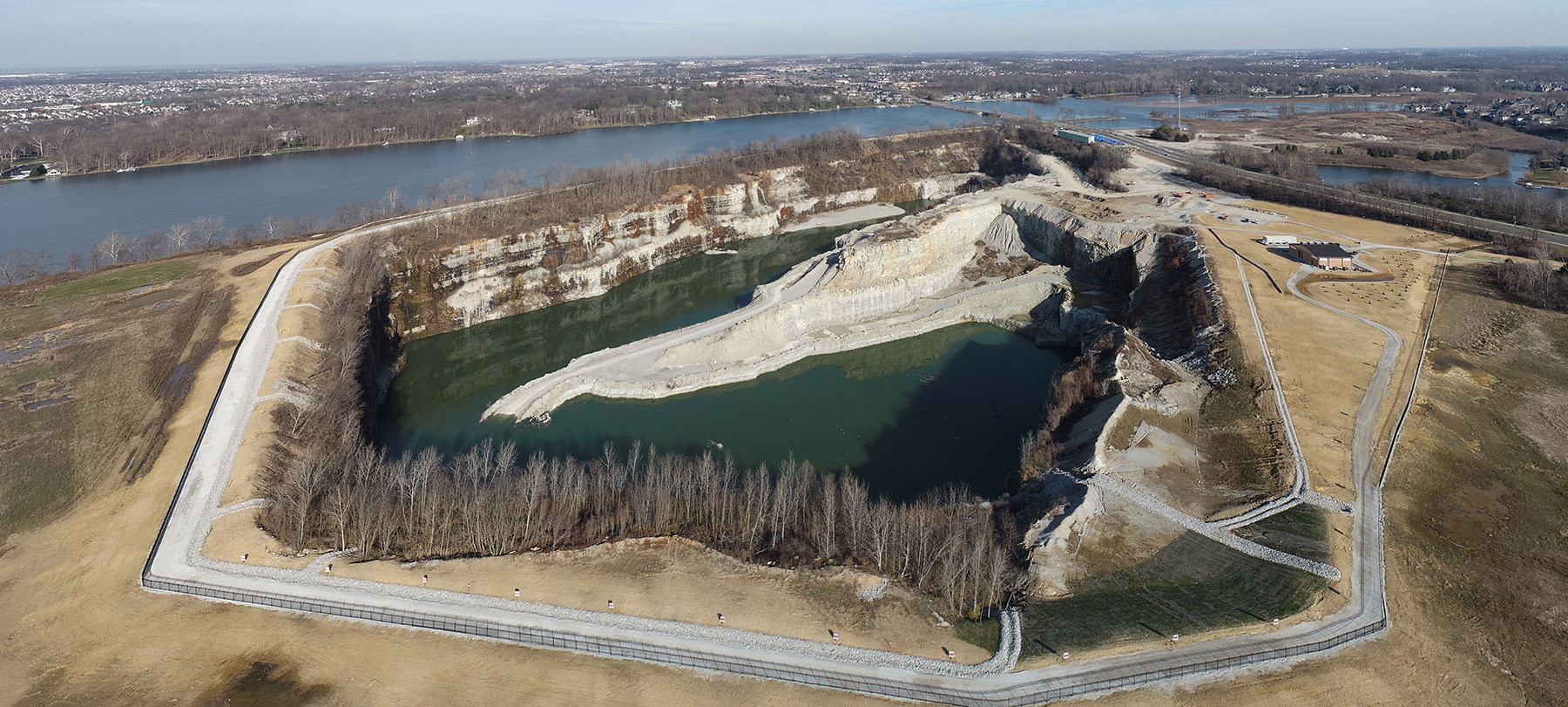 Decommissioned rock quarry showing water, trees, and sloped land