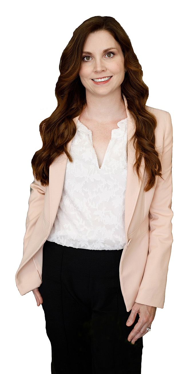 Woman in pink blazer, white blouse, and black pants smiles. 