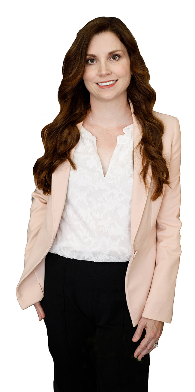 Woman in pink blazer, white blouse, and black pants smiles.