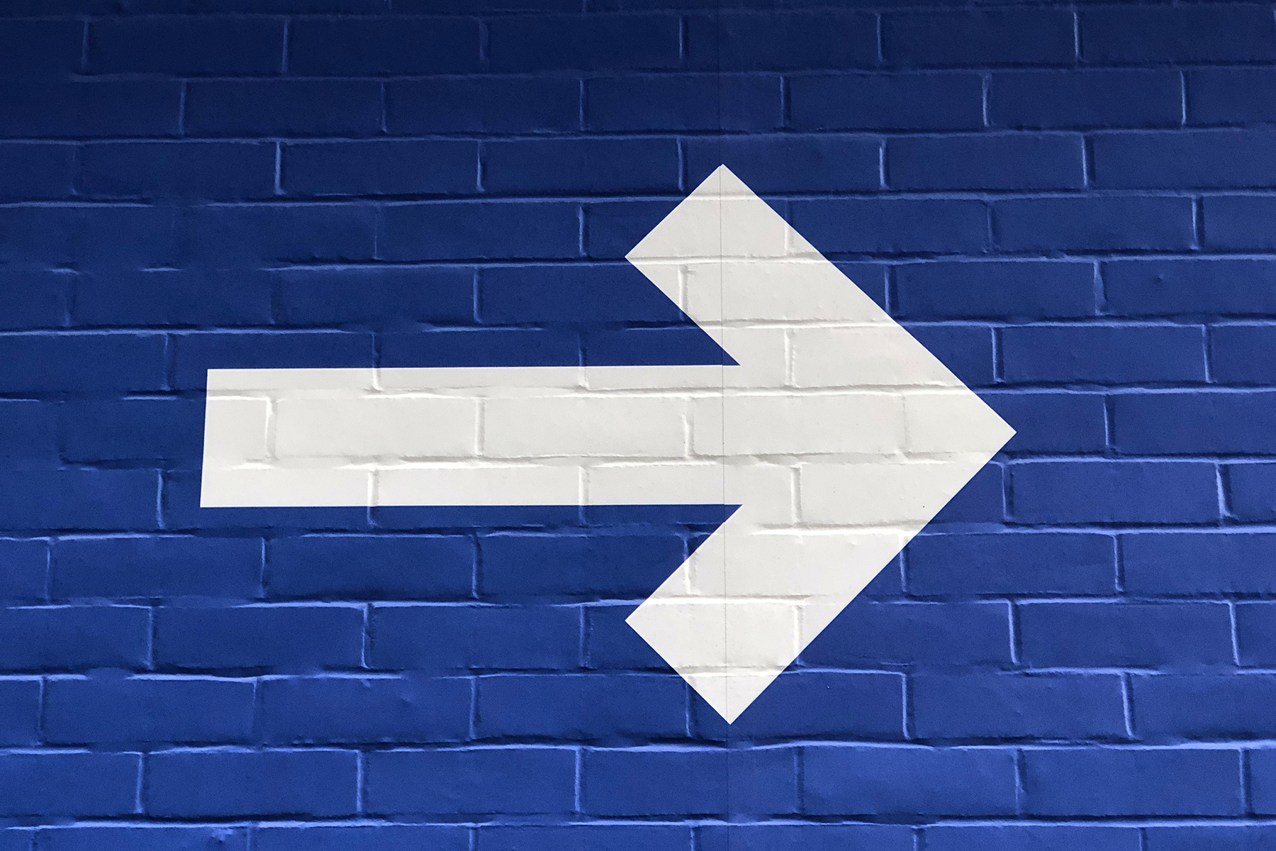 white arrow pointing right on a blue background