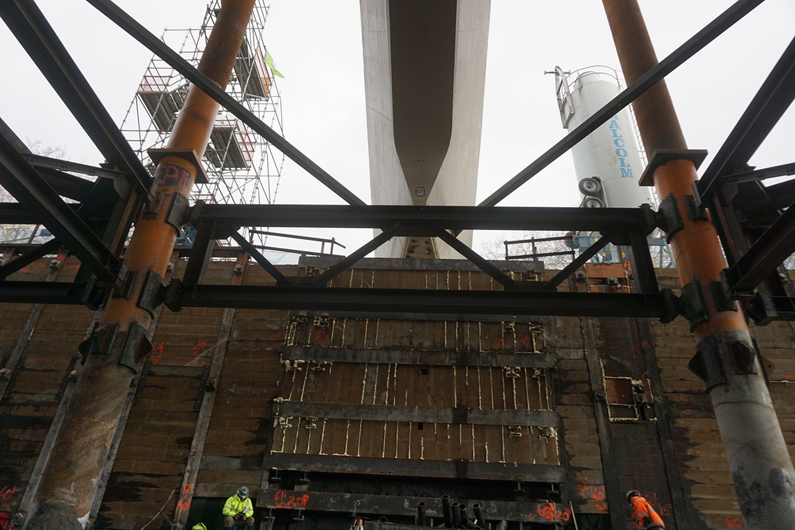 Horizontal steel waler beams and vertical wood lagging beneath a pylon. (Image courtesy of Thornton Tomasetti)