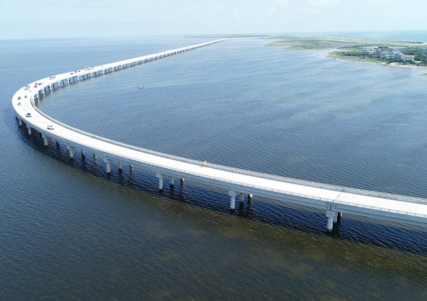 Uniquely shaped bridge curves over a large body of water.