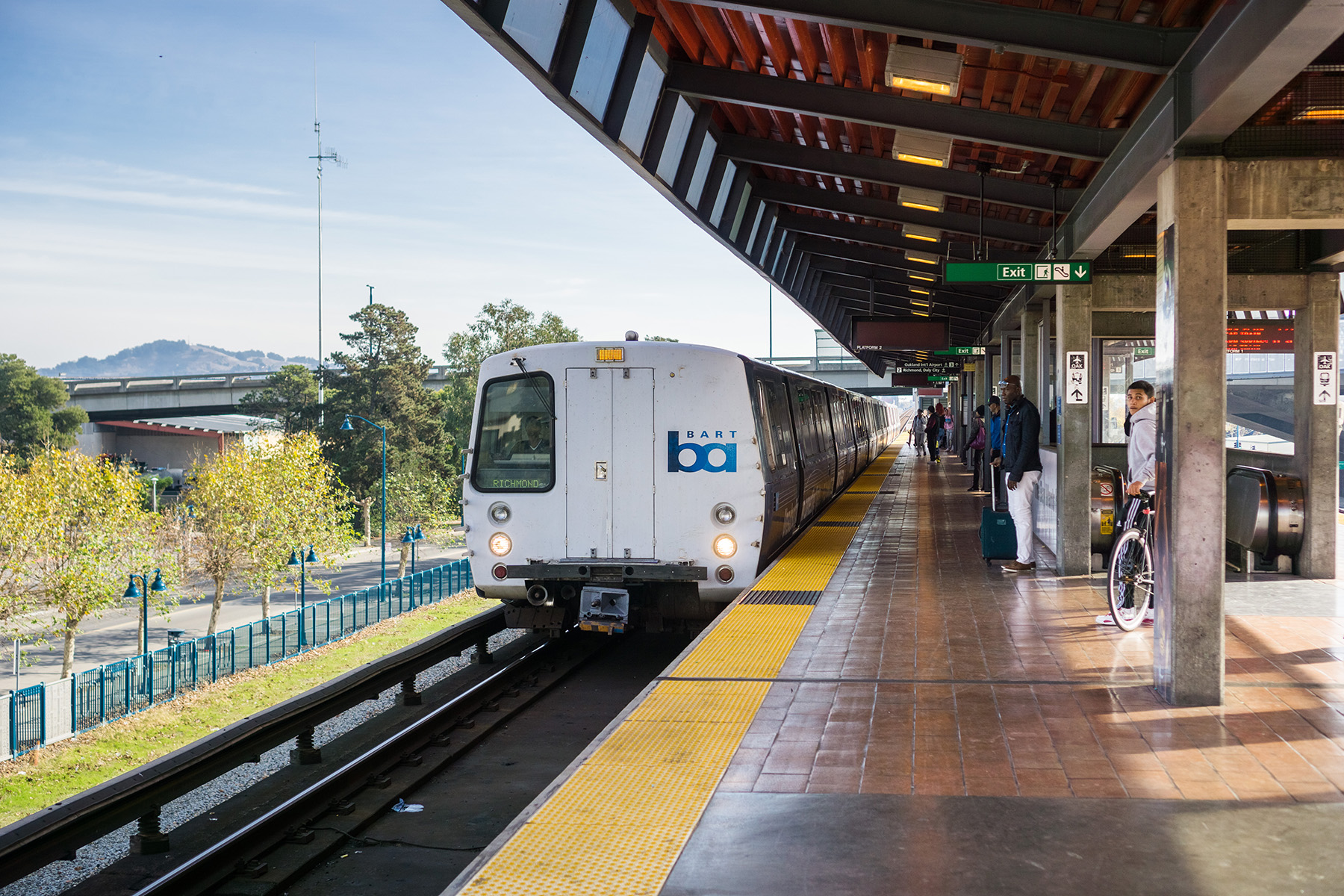 train on a platform while people wait to board it.