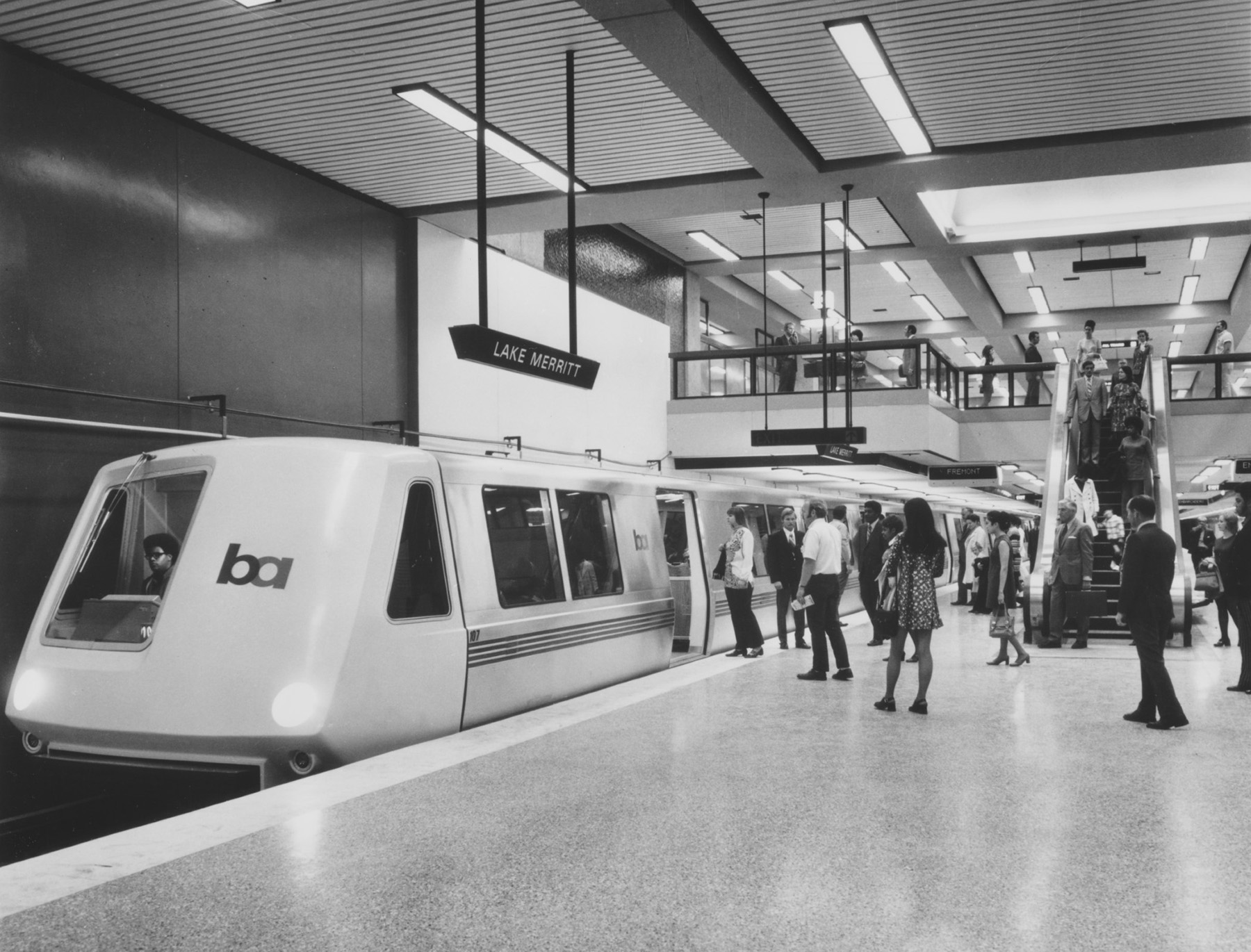 Train on a platform while people wait to board it.