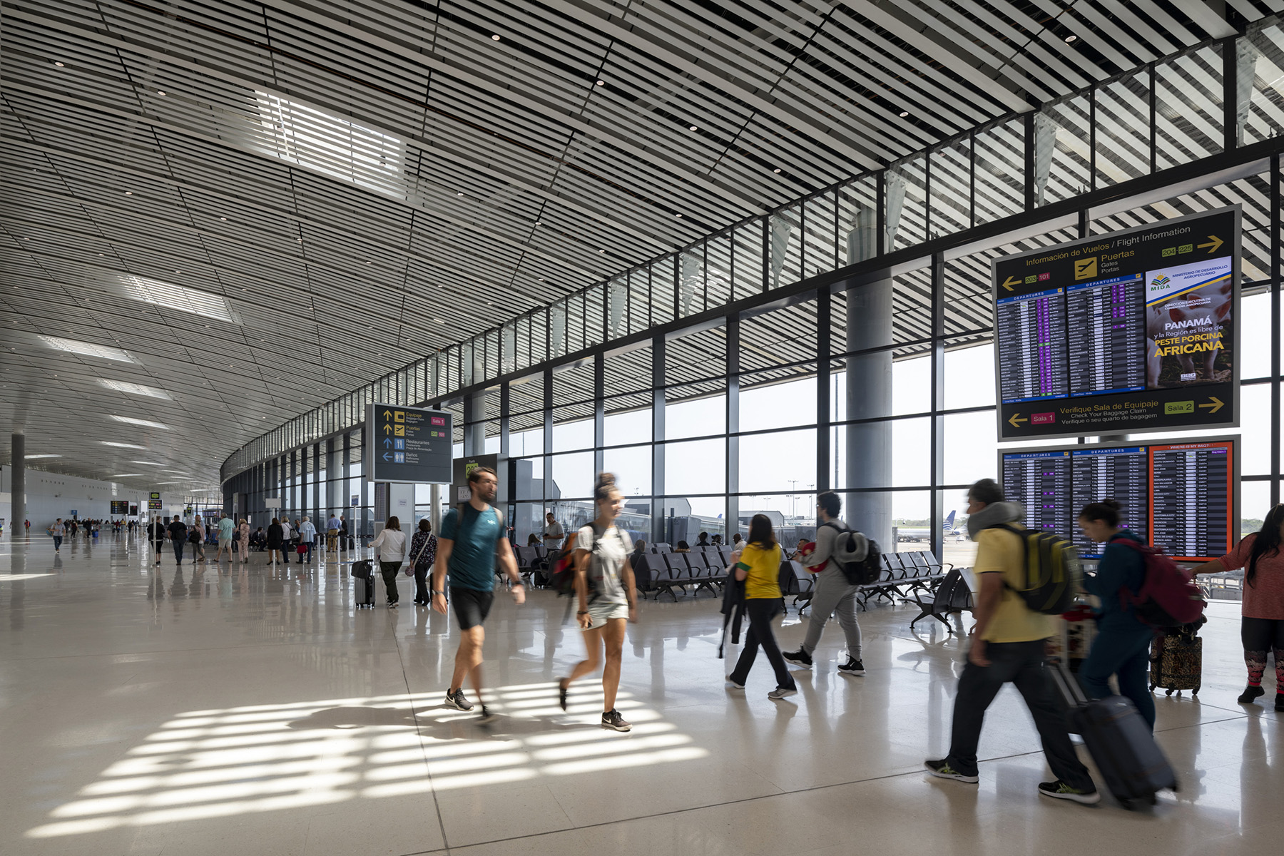 People walk through an airport terminal.