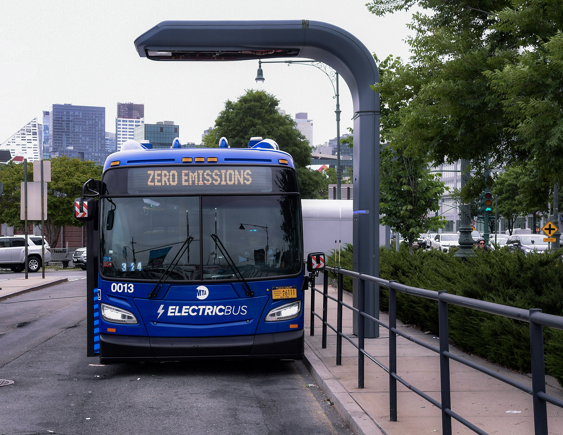 A blue bus is parked at a station.