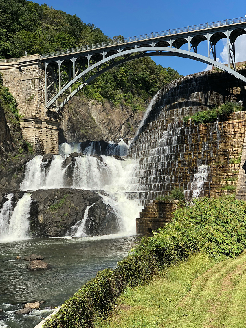 Water in a dam flowing over large rocks. 