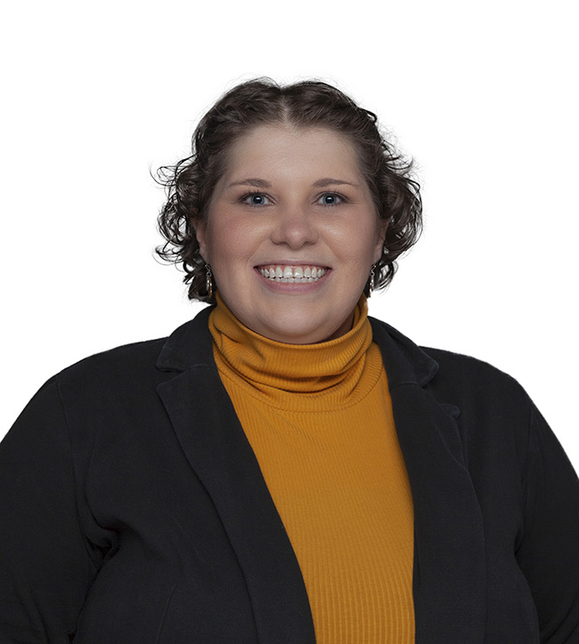 Woman in orange turtleneck and black blazer.