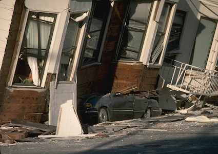 An automobile lies crushed under the third story of this apartment building in the Marina District in San Francisco after the Loma Prieta earthquake on Oct. 17, 1989. The ground levels are no longer visible because of structural failure and sinking due to liquefaction. (Image courtesy of John K. Nakata/USGS)