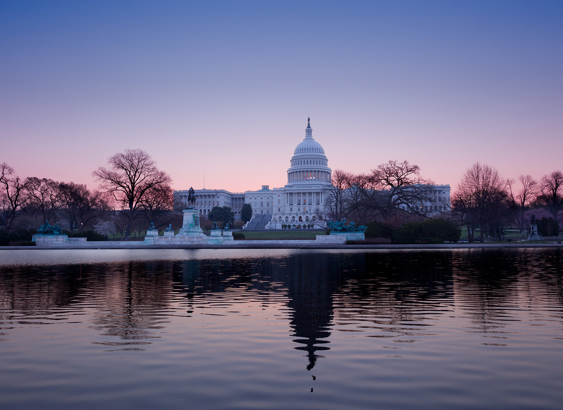 Photo shows the back of the U.S. Capitol building at dusk. 