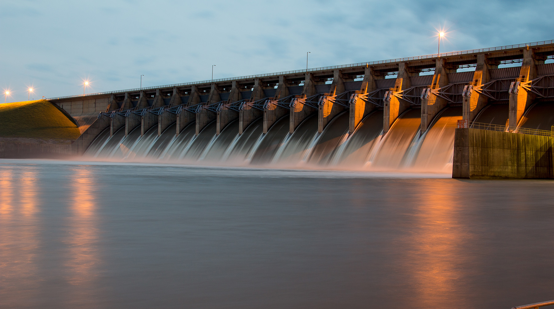 Water pours through the gates of a dam.
