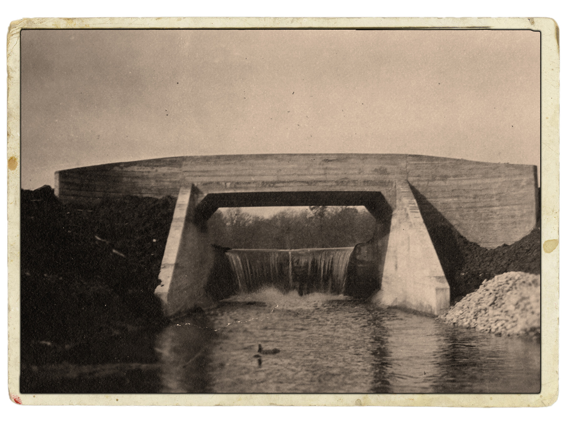 Historical photo shows lake with a dam.