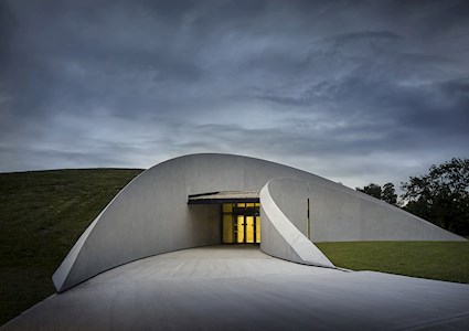 Curved walls lead to the main entrance. (Image courtesy of Hufton + Crow)