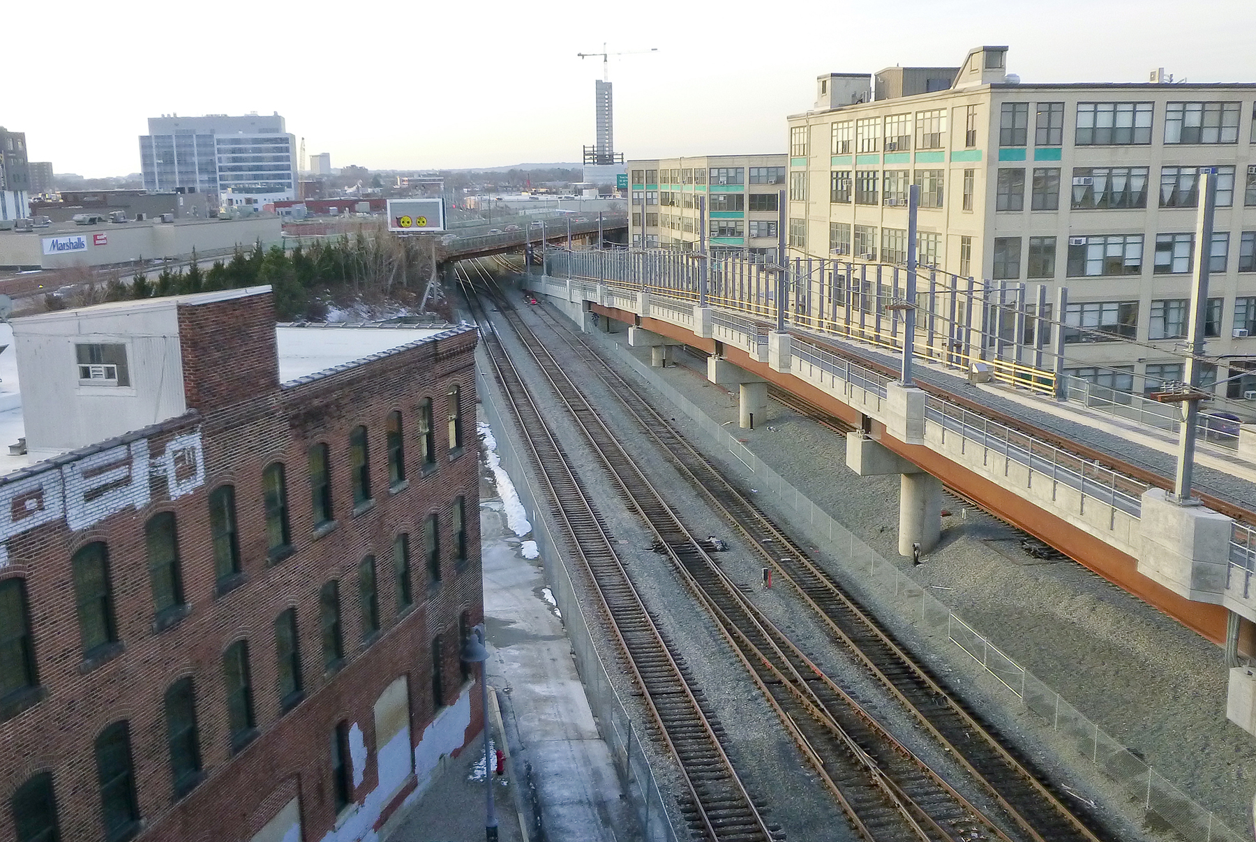 Much of the new Green Line extension is in the right of way of existing commuter rail lines. Here an elevated portion of the westbound Union Square Branch viaduct parallels the Fitchburg Line of the MBTA's commuter rail system. (Image courtesy of GLX Constructors) 
