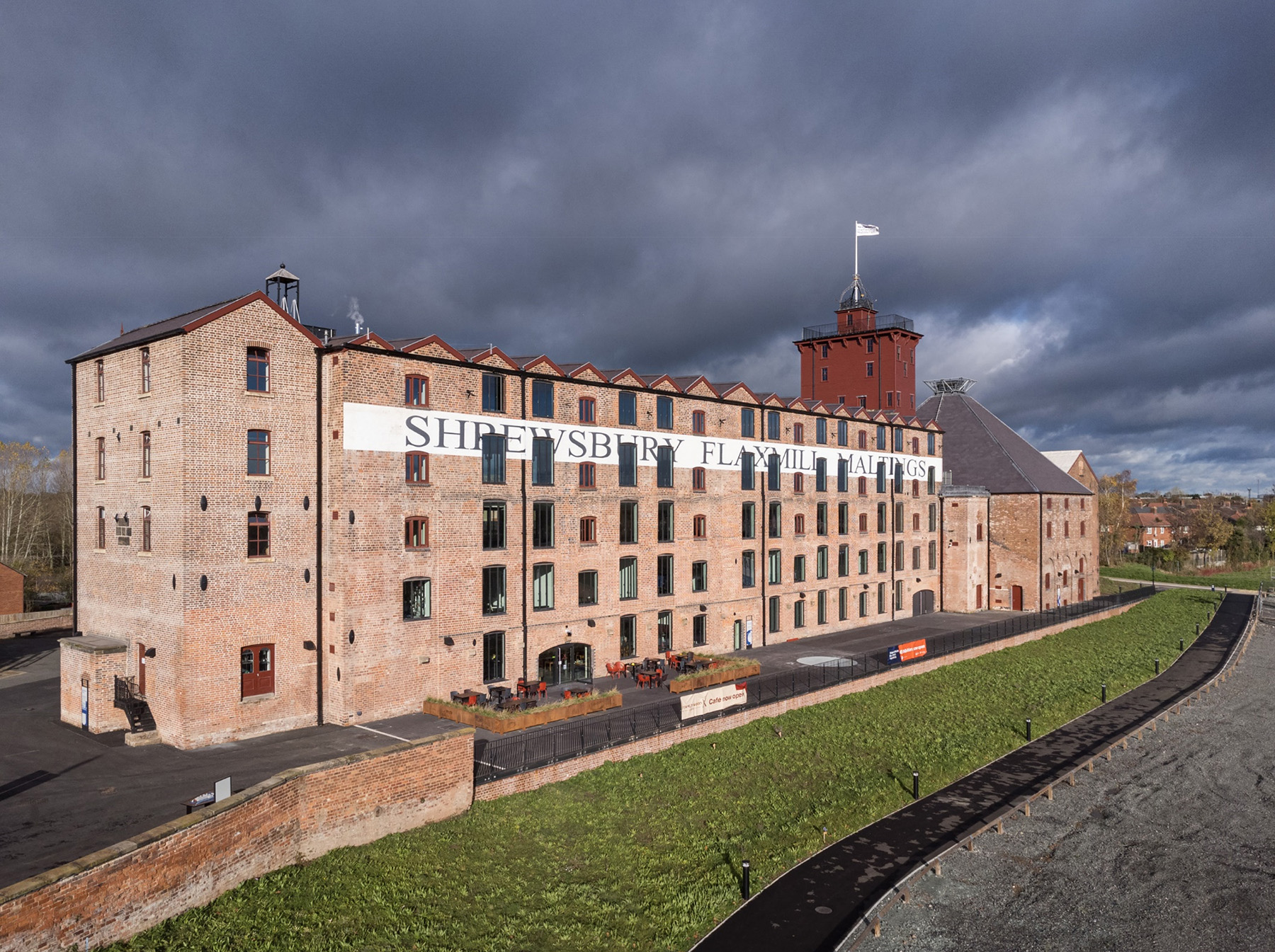 Multistory brick building with the words “Shrewsbury Flaxmill Maltings” written on the side. 