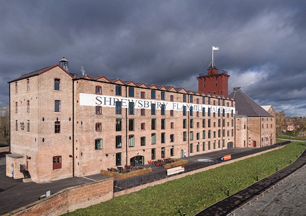 Multistory brick building with the words “Shrewsbury Flaxmill Maltings” written on the side.