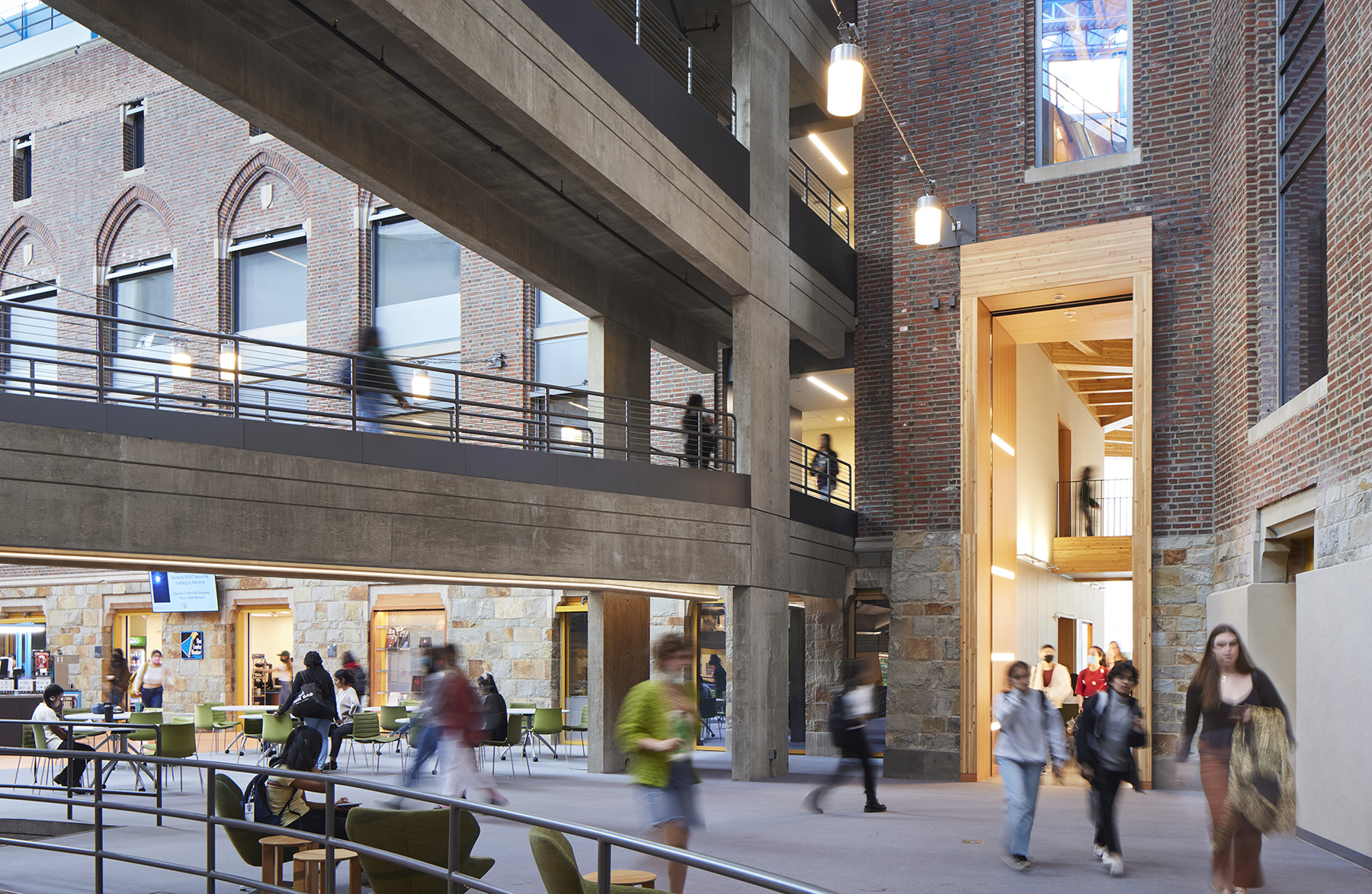 Students walk through a large multistory space.