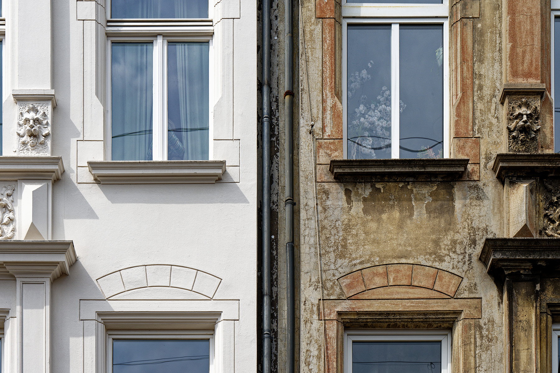 Two photos side by side show a restored façade and one that has not been restored. The restored one is white marble, and the unrestored one is weathered and rusted. 