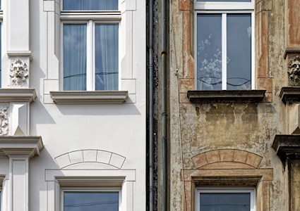 Two photos side by side show a restored façade and one that has not been restored. The restored one is white marble, and the unrestored one is weathered and rusted.