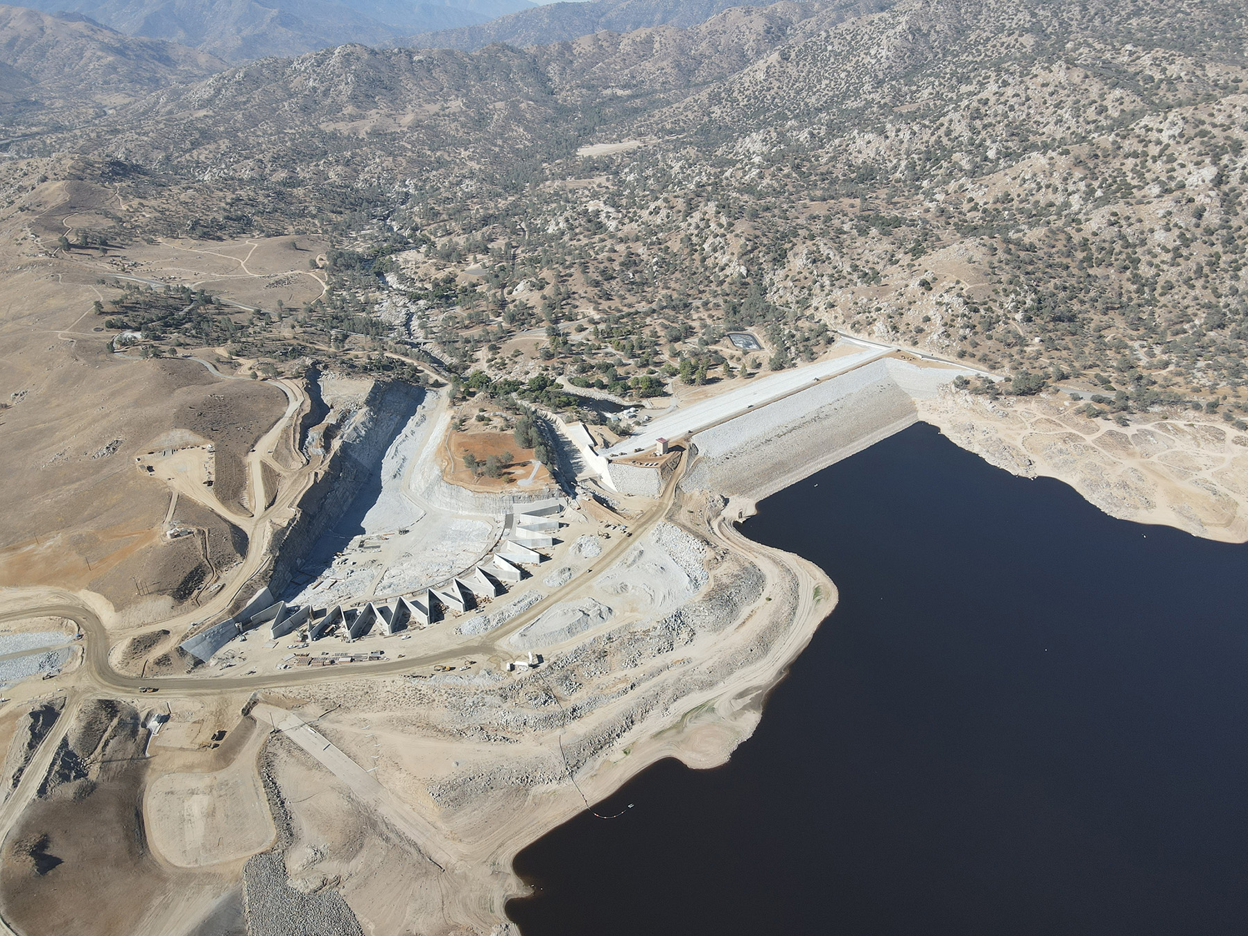Aerial photograph of a dam surrounded by a barren landscape