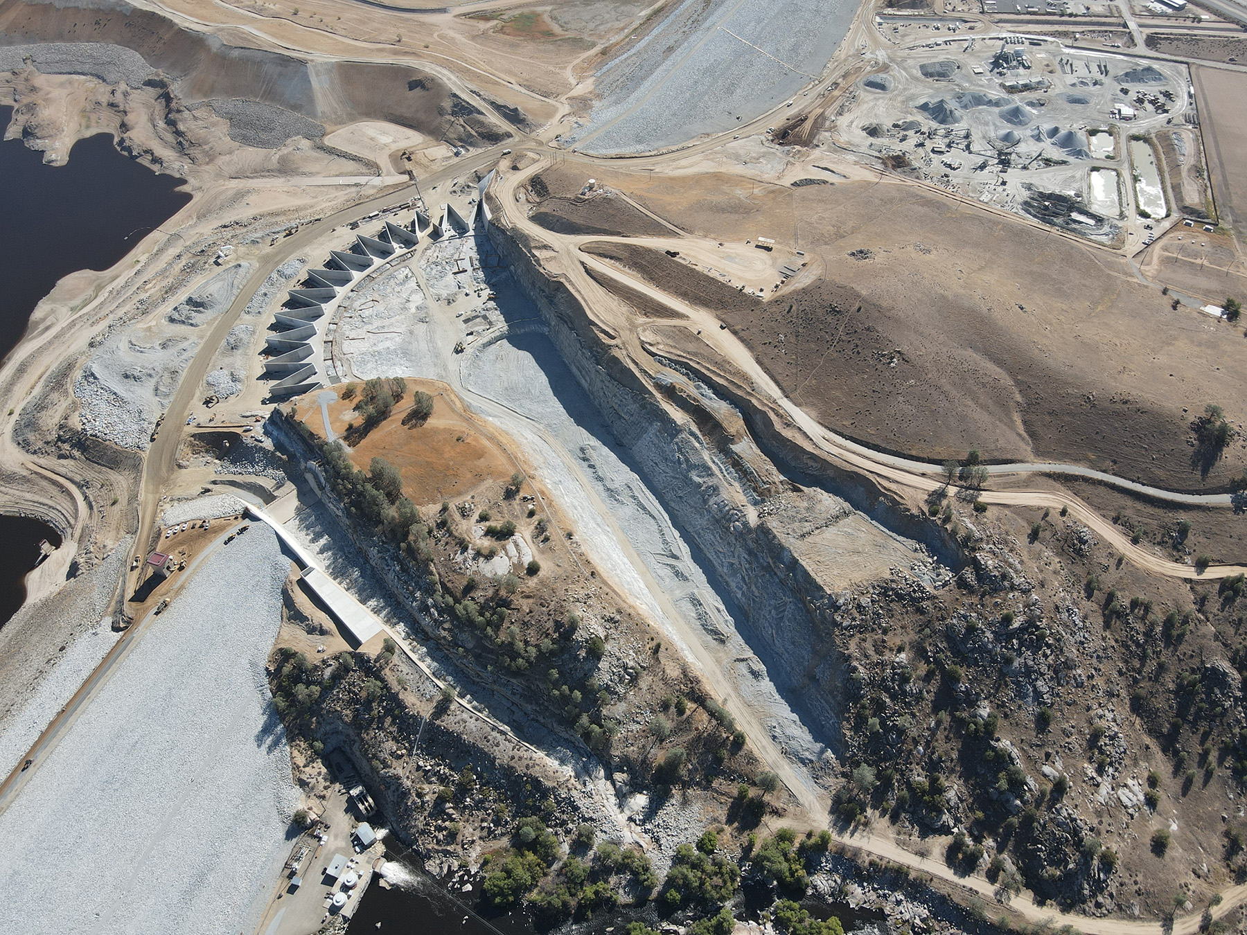 Aerial photograph of a dam surrounded by a barren landscape.